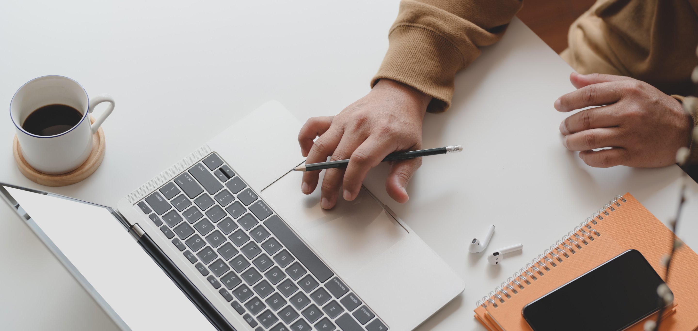 Person Holding Black Pen While Using Laptop